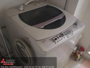 Washing machine with digital controls and top-loading design in a home laundry room.