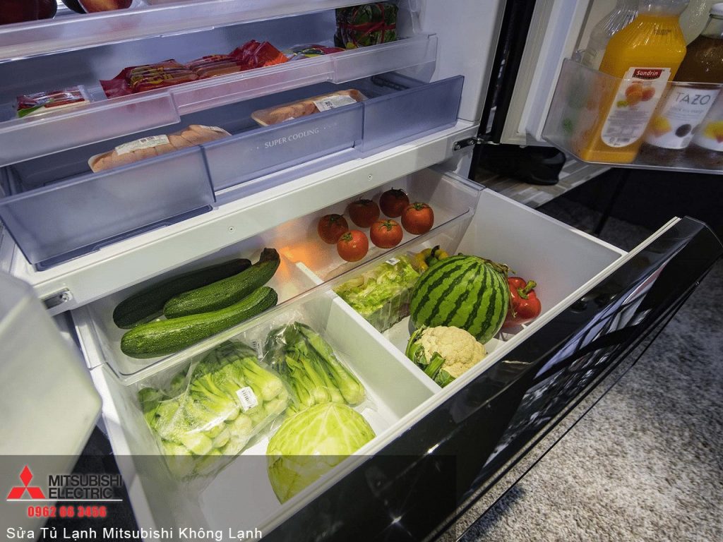 Fresh assorted vegetables and fruits organized inside a Mitsubishi refrigerator for optimal cooling and preservation.