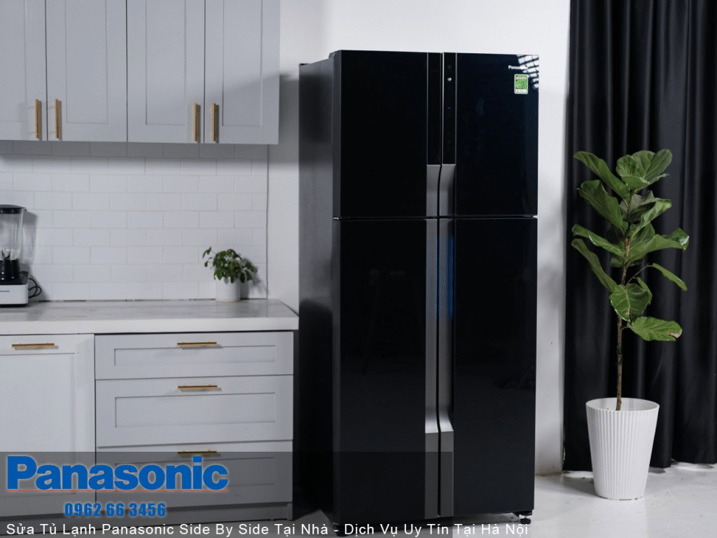 High-capacity black Panasonic refrigerator in modern kitchen with white cabinets and decorative indoor plant.