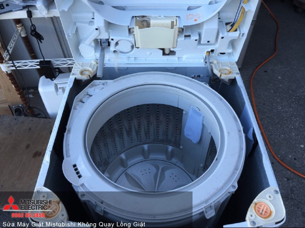 Washer machine repair, no drum spin, Mitsubishi electric washing machine, top view, open lid, internal drum, maintenance work, laundry appliance, appliance servicing, repairing washing machine, technical equipment, home appliance repair, Mitsubishi washer repair, front load washing machine, service technician, appliance maintenance, repair workshop, laundry care, washing cycle, household appliance, electronic repair, service and support, washing machine troubleshooting, repair service, domestic appliance repair, professional appliance service, close-up of washing machine interior, open washing machine lid, equipment repair, laundry appliance service, washing machine motor.